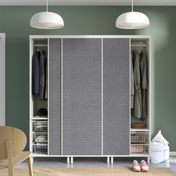 Modern closet with sliding doors, hanging clothes, shelves, and overhead lighting, set against green walls.