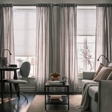 Modern living room with automated, cordless blinds and remote control for comfort and style.