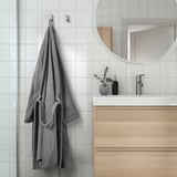 Modern bathroom with gray ROCKÅN bathrobe, hooks, belt loops, side pockets, and wooden vanity.