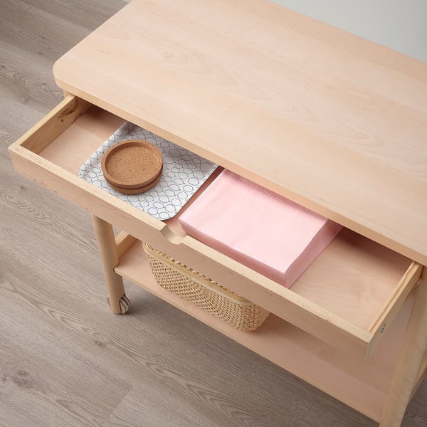 Light wooden trolley with drawer open, revealing storage boxes and a round woven coaster. Suitable for kitchen or dining area organization.