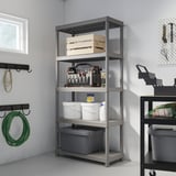 Gray 4-tier RUNMARÖ shelf with tools, near window & hose rack.