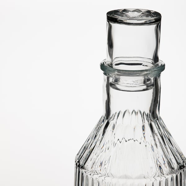 Clear glass carafe, etched with intricate design, featuring a secure lid and elegant structure.