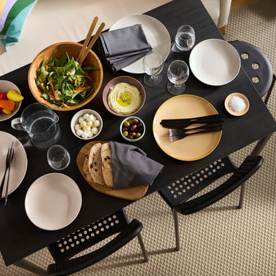An all-black sandberg table. It a rectangular top and slender metal legs, blending wood and metal in a slim, modern design.