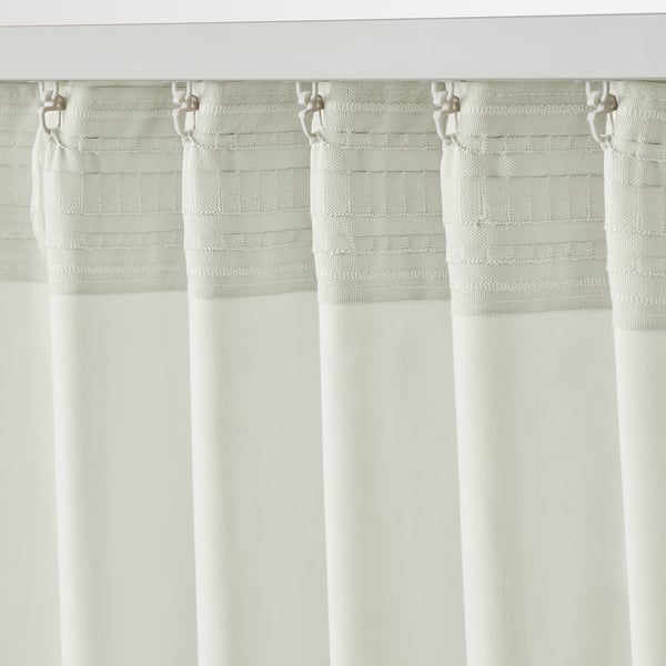 Textured white curtains with multi-way header, offer privacy & light filtering.
