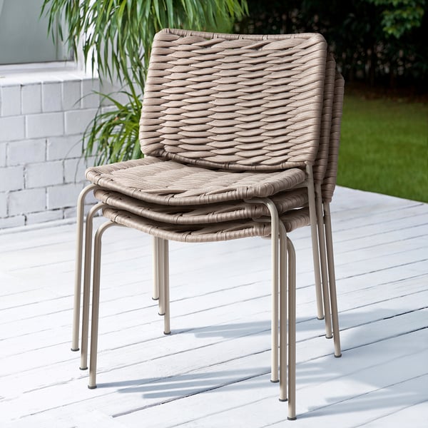 Stacked outdoor chairs, beige wicker, beige metal frame.