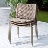Stacked outdoor chairs, beige wicker, beige metal frame.