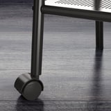 Modern metal bedside table with wheels, featuring perforated shelf, on sleek wooden floor. Quality and design.