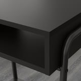 Modern black bedside table with sleek metal legs and smooth surface.