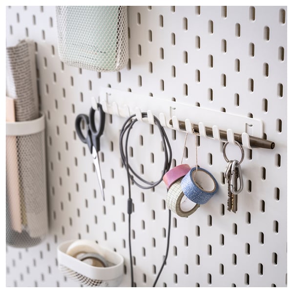 SKÅDIS white pegboard with accessories: scissors, keys, cables, and tape. Organized, modern storage solution.