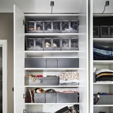 Closet with white shelves, gray SKUBB boxes for shoe storage, some folded clothes.