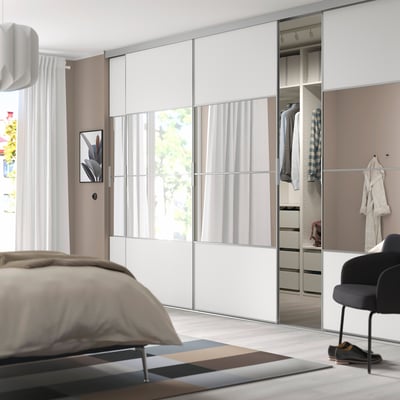 SKYTTA wardrobe in bedroom, mirrored panels, hanging & shelving, pendant lamp, black chair.