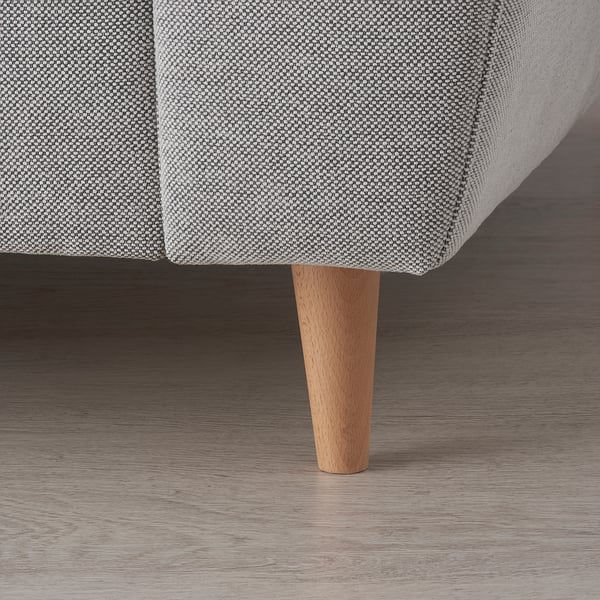 Close-up of a stylish sofa leg with light wood texture, part of a modern, comfortable piece of furniture.
