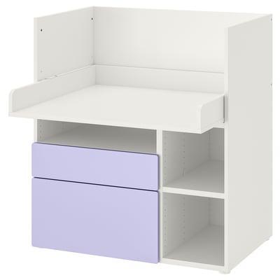 An IKEA SMÅSTAD white desk with purple drawers. It has open shelves and a flat top, ideal for a childs room.