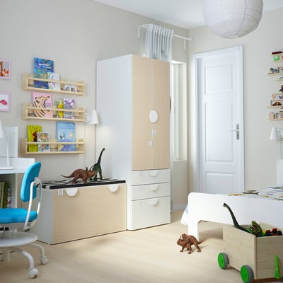 Kids room with wood furniture, colorful books, blue chair, dinosaur toys.