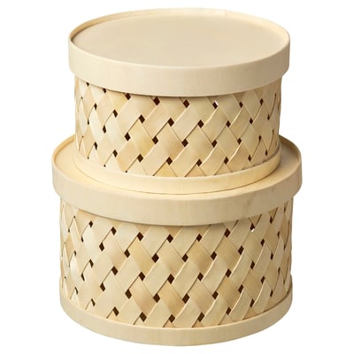 Two light-colored, round woven baskets with lids, stacked side by side.