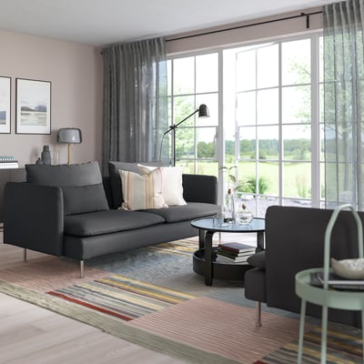 Modern living room with large grey SÖDERHAMN sofa, striped rug, and floor lamp, centred near large windows.