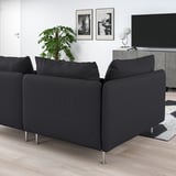 Modern black l-shaped SÖDERHAMN sofa on wooden floor, near tv, rug, and plant.