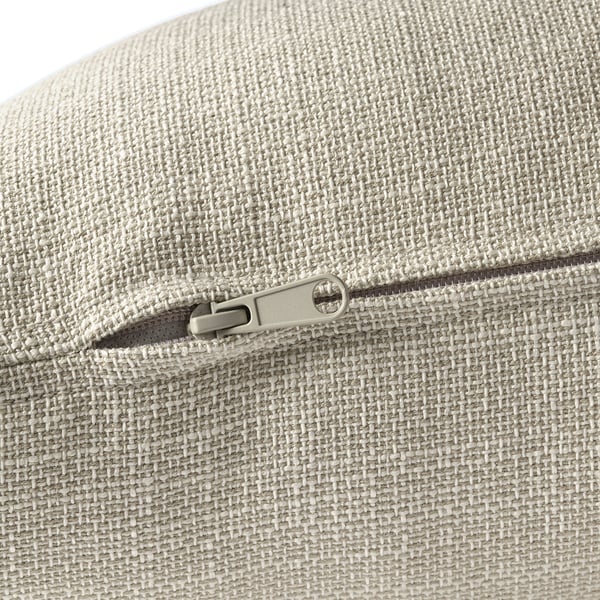 Close-up of a zipper on a soft, textured, beige upholstered cushion.