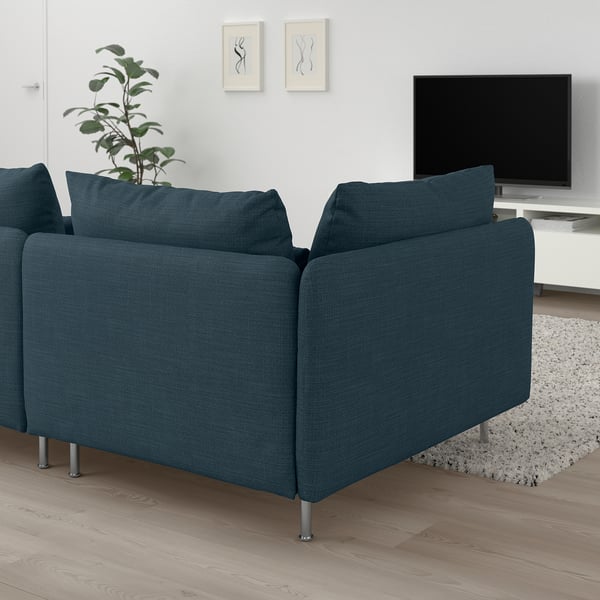 Modern living room with large, blue SÖDERHAMN sectional sofa, large cushions, and metal legs. Flat screen tv and greenery nearby.