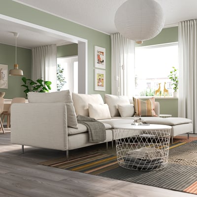 Modern green living room with SÖDERHAMN sectional sofa, colorful rug, and wooden coffee table.