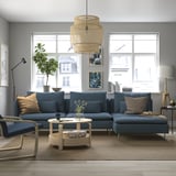 Modern living room with blue sectional sofa, coffee table, and city view.