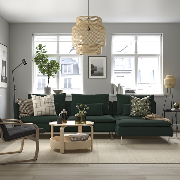 Modern room: green l-shaped SÖDERHAMN sofa, natural wood coffee table, large windows, plants, art, soft lighting.