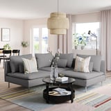 Modern grey SÖDERHAMN section sofa with cushions, striped rug, large hanging lamp, and potted plants, positioned near a window with curtains.
