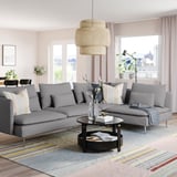 Modern living room with large gray SÖDERHAMN sectional sofa, stylish pendant lamp, colorful rug, and large windows offering city views.