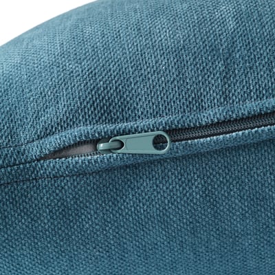 Close-up of a zip on a high-quality, textured teal sofa cushion with a smooth, reflective fabric.