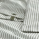 Close-up of striped SOLFIBBLA shirt. Light green button near cuff, showing dense thread weave. Fabric has 46 threads per square cm.