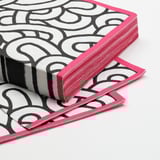 Stack of stylish, highly absorbent pink-edged napkins with black and white patterns.