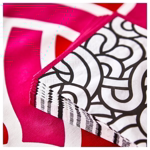 Bright pink and white patterned napkin with intricate designs, showing three layers indicating high absorbency.