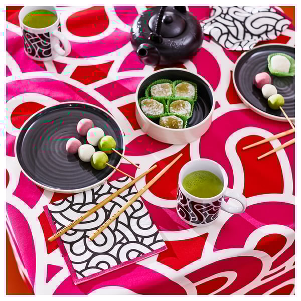 SÖTRÖNN red paper napkin, large, round, bold geometric design, placed under cups and plates on table.