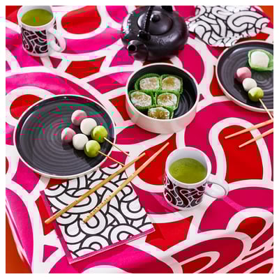 SÖTRÖNN red paper napkin, large, round, bold geometric design, placed under cups and plates on table.