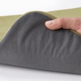 Hand touching gray mesh surface of STAGGSTARR chair pad, showing removable and washable cover.