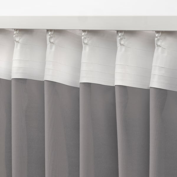 White and grey curtains with tabs for hanging, showcasing sheer fabric designed to diffuse light.