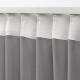 White and grey curtains with tabs for hanging, showcasing sheer fabric designed to diffuse light.