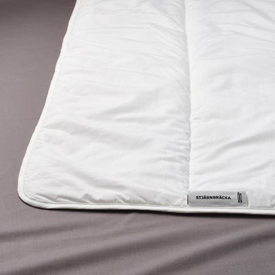 Folded white STJÄRNBRÄCKA duvet, soft with breathable fabric for comfort, even sleeping temperature.