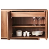 Walnut sideboard with adjustable shelves, white tableware, push-open doors.