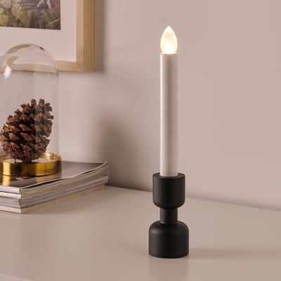 Modern table lamp: white, black base, warm light, battery-operated.