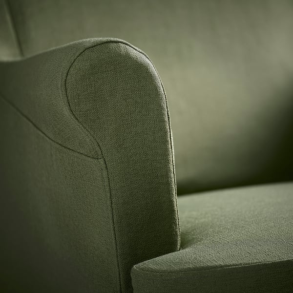 Close-up of a high-quality, dark green fabric sofa armrest. Shows smooth, durable texture and neat stitching.