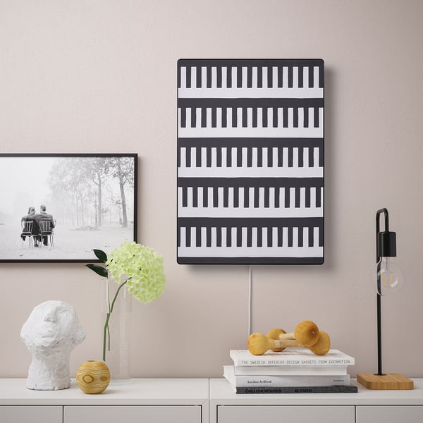 SYMFONISK speaker with stripes on shelf, photo, sculpture, vase, books, lamp.
