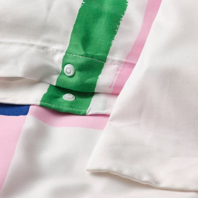 Close-up of duvet covers vibrant green and pink stripes with plastic press-stud closure.