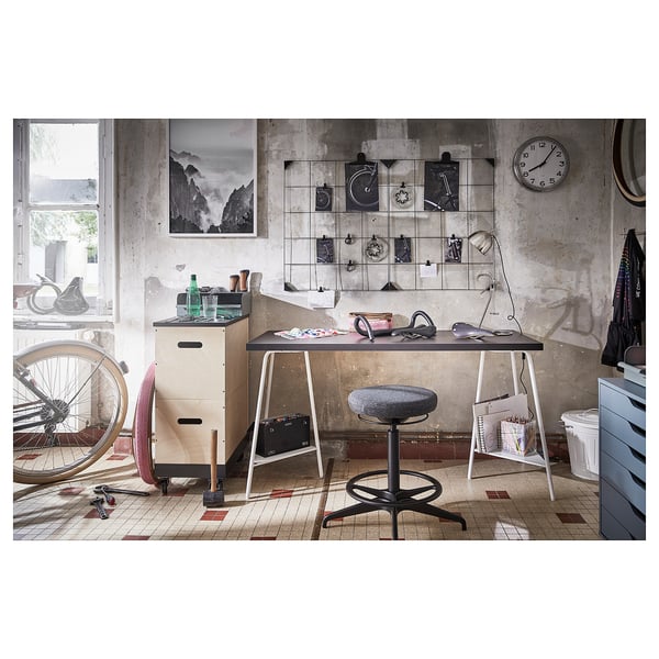 Unique home office setup with white desk, black chair, wall clock, and bicycle-themed decor.