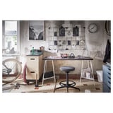 Unique home office setup with white desk, black chair, wall clock, and bicycle-themed decor.