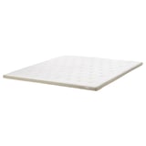 A TISTEDAL mattress pad in white. It a natural latex core and breathable fabric. The edges have a textured linen design.