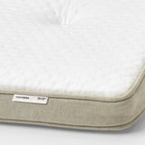 Close-up of a TISTEDAL latex mattress pad showing its textured surface and high-quality materials.