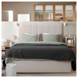 Cozy modern bedroom with TJÅLLE headboard in beige, stunt fabric, rectangle shape, soft padded design, matching bedding, wooden cabinets, walls.