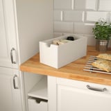 White kitchen storage box, on counter, with various items. Ideal for accessible, organized storage.