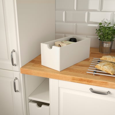 White kitchen storage box, on counter, with various items. Ideal for accessible, organized storage.